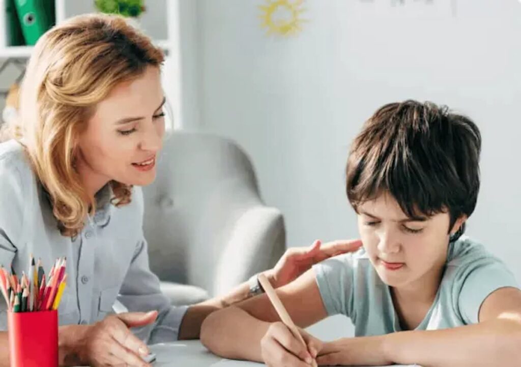 teacher supporting child with writing during dyslexia support session